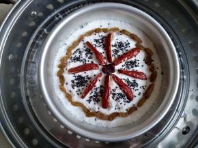 将剩余的粉倒入，再抹平，切记不要压实。在上面摆放各种干果。