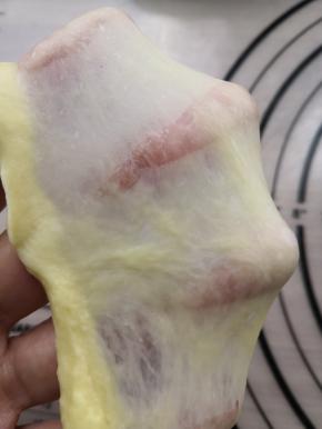 揉到光滑的面团后，加入提前软化好的黄油，继续揉面，揉到完全扩展阶段，既手套膜