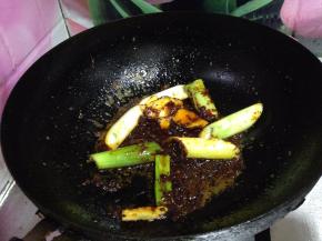 下入葱姜、料酒炒匀