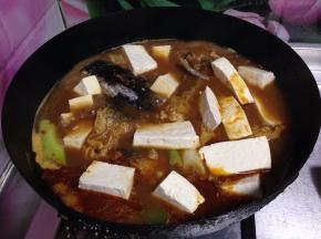加入料酒、大料、花椒、豆腐块煮10分钟后，加入盐、糖调味小火再炖煮入味即可