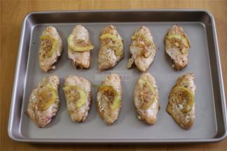 腌制好的鸡翅放入烤盘，把柠檬片放在鸡翅上面。