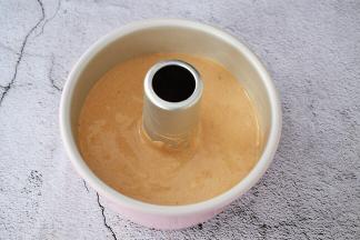 把拌匀的蛋糕糊倒入学厨6寸的中空模具中，端起模具的两端，指拇按住中空柱上空，轻轻震几下，震出大气泡