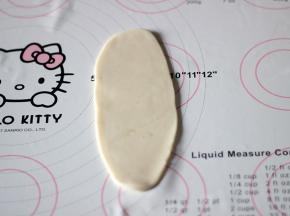 将包好的面团放在工作台上，擀成牛舌状