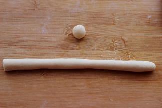 把切好的帽子盖在白面皮上，另取一小点白色面团做一个小圆蛋、再用一小块面团搓成长条备用