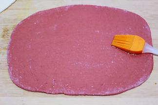 用硅胶刷子蘸少许食用油均匀涂抹在红色的面皮上，上面撒上少许的盐。
