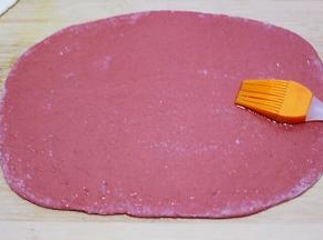 用硅胶刷子蘸少许食用油均匀涂抹在红色的面皮上，上面撒上少许的盐。
