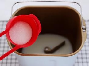 先把牛奶倒入面包桶中，加入甘汁园白砂糖，最近朋友用的都是这个双碳白砂糖，听说是无硫的比较健康，好溶解。