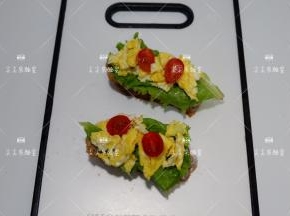 在放上炒好的鸡蛋和小番茄