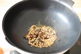 热锅后倒入适量菜油，将腌制好的肉糜倒进去翻炒至变色后再倒入香菇丁一起炒熟盛出备用；