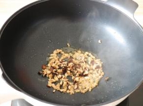 热锅后倒入适量菜油，将腌制好的肉糜倒进去翻炒至变色后再倒入香菇丁一起炒熟盛出备用；