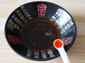熬煮好的酸汤倒入面碗内，加入一小勺红油；