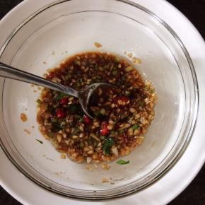 把大蒜瓣、小米辣切碎放入碗里，加入10克陈醋、5克味事达味极鲜酱油、5克橄榄油、2克y白糖、2克盐（里面我切了几根香菜梗）搅拌一下备用。