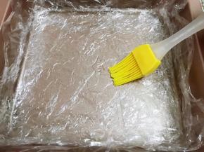 8寸烤盘里铺上厚保鲜膜，刷上一层芝麻油