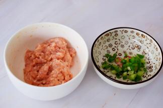 猪肉剁成末加入盐、淀粉、食用油搅打均匀腌制备用，葱切葱花