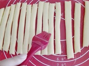 用刮板切成条，双手拿住面条的两端，反方向拧成型。放入烤盘。普通烤盘需垫油纸或锡纸