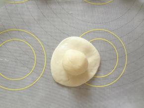 水油皮用手按扁，中间厚边缘薄，放上油酥用虎口慢慢往上收捏紧收口向下