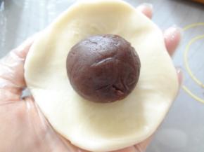 擀成中间厚边缘薄的皮放上玫瑰豆沙同样用虎口向上收，