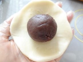 擀成中间厚边缘薄的皮放上玫瑰豆沙同样用虎口向上收，