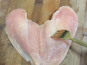 用叉子把鸡胸肉均匀的叉上小孔，以便腌制的时候，更容易入味儿。