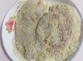 最后再均匀的裹上一层面包糠。按压紧实，把多余的面包糠拍掉。