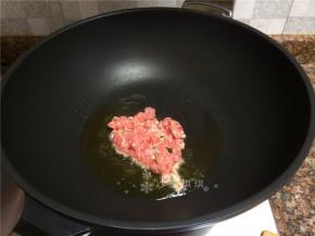 放入肉丁快速翻炒至变色断生。