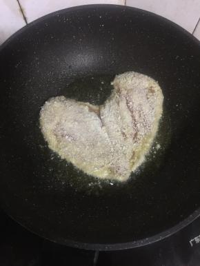 不粘锅烧热倒入适量的油，放入鸡胸肉中小火慢慢煎制。