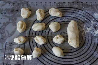 静置后的面团在案板上揉光滑，分成30克1个的面团12个，余下的留作蘑菇柄。