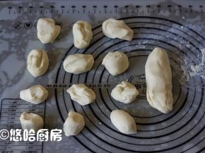 静置后的面团在案板上揉光滑，分成30克1个的面团12个，余下的留作蘑菇柄。