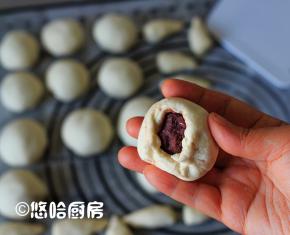 分开的小面团揉光滑，擀开，包入14克左右的豆沙馅，像包包子一样捏紧收口。