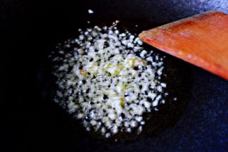 另起锅倒入花生油烧热后、放入用刀切碎的蒜末爆出香味后。