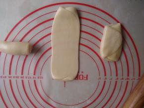 将面皮用手掌压一下，擀成长舌形，再卷起来，松驰15分钟