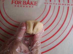 拇指按压面卷的中间，让面卷呈对折状态