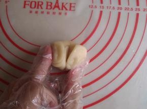 拇指按压面卷的中间，让面卷呈对折状态
