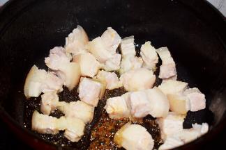 放入五花肉，翻炒至上糖色