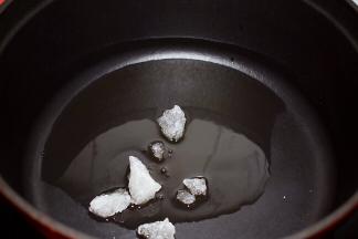 锅中倒入适量的食用油烧热，放入冰糖，小火翻炒至冰糖融化，变成焦黄色