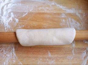 用擀面杖将面卷起来，反复先向前然后再向后擀。
擀的时候稍稍向下压，给面一个压力，这样面就越擀越薄。