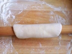 用擀面杖将面卷起来，反复先向前然后再向后擀。
擀的时候稍稍向下压，给面一个压力，这样面就越擀越薄。