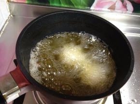 锅内加油烧至4成热，下入丸子