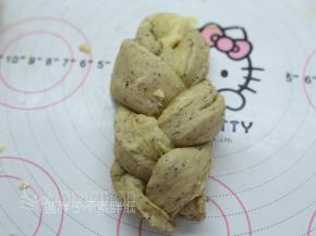 松弛好的面团压扁，再次擀开成长条。用刮刀将面团分成3份，记得开头部分不要切断。将面团编成辫子形状，收口捏紧。