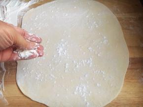 直到擀成一个薄薄的面饼，再撒上面粉。