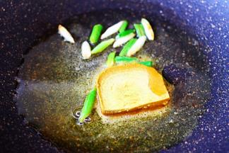 热锅倒入橄榄油烧至六成热时，放入小葱爆出香味后，放入20克好侍百梦多咖喱块。