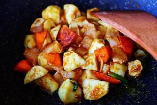 继续用锅铲慢慢翻炒片刻，看见鸡脯肉块炒至变色的时候。