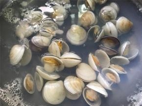 取一锅倒入适量水，煮开后加入老姜片和料酒，再把洗干净的文蛤放入锅中，等文蛤开口即可熄 火。