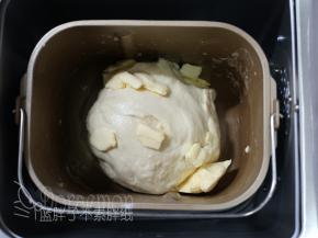 10分钟后，面团能够拉出厚膜，加入软化好的黄油，继续和面程序15分钟。