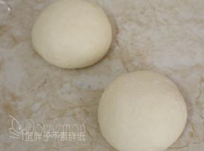 将发酵好的面团排气后分割成2份，将面团滚圆，盖上保鲜膜，松弛15分钟。