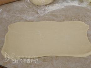 将松弛好的面团用擀面杖擀成长方形。
