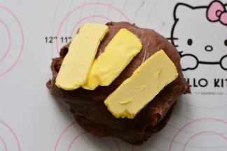 揉面10分钟后，揉至面团光滑，加入软化的黄油，揉至完全吸收