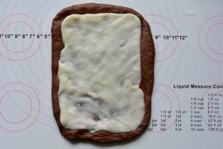 静置好的面团擀开，麻薯擀成和面团差不多大小的片状，放在面团上