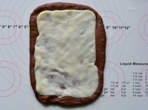 静置好的面团擀开，麻薯擀成和面团差不多大小的片状，放在面团上