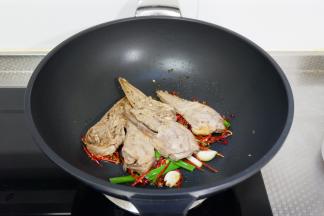 加入鸭头翻炒几下